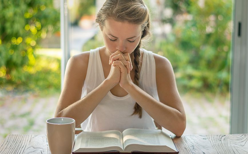 Mulher com um livro e em oração