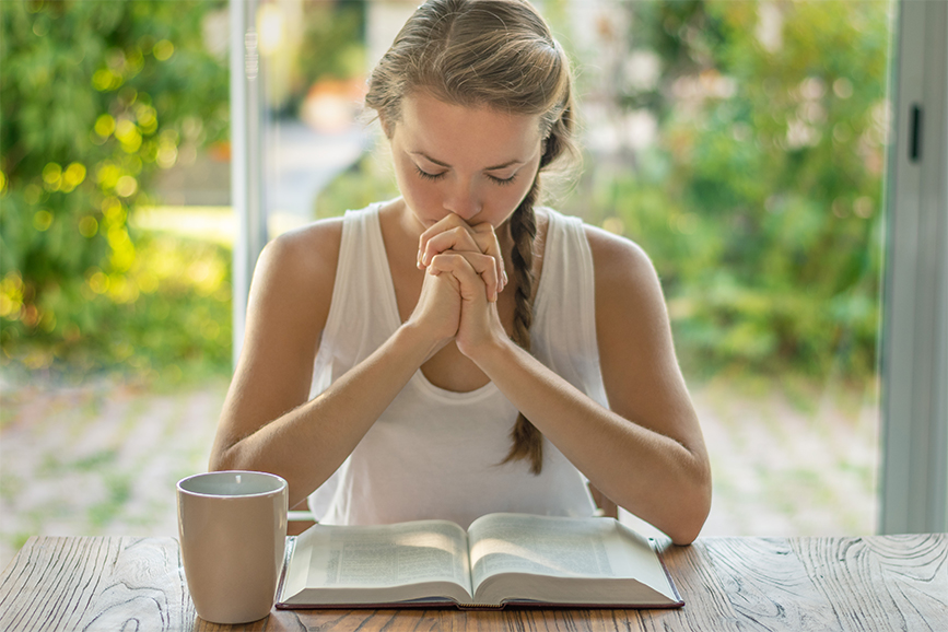 Mulher com um livro e em oração